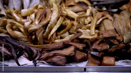 Variety of smoked sea fishes and other seafood on the counter in a fish shop, slow motion