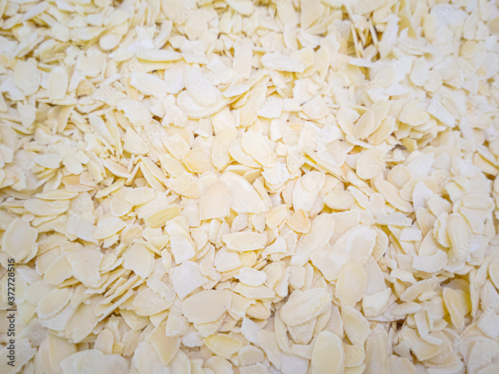 Obraz premium Almond shavings close up. Lots of nuts in the market. Healthy organic food concept. Nut flakes, petals.