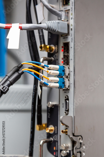 Fiber optic cables are connected to radio relay equipment. Close-up. Vertical orientation. 