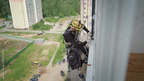 Steeplejacking. Professional rope access technician works outside the building