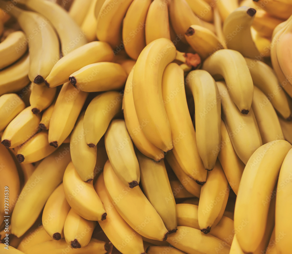 Delicious ripe bananas with a soft yellow skin are in the grocery store. Background of fruit. Rich harvest.
