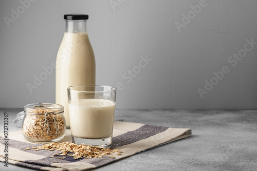 Vegan oat milk with oat flakes close up photo