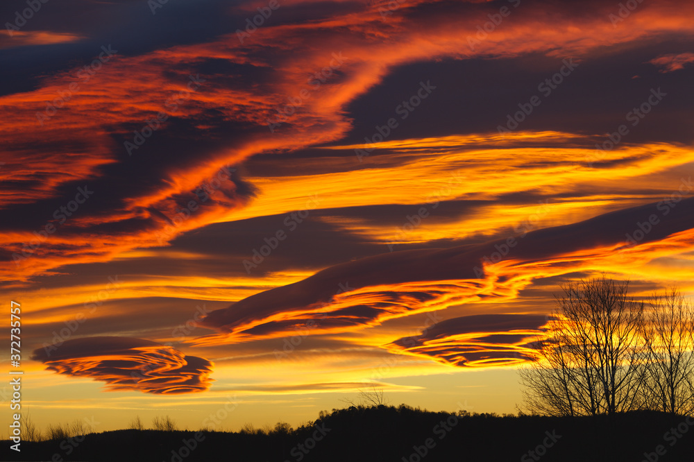 Dramatic sunset in red tones with lenticular clouds.