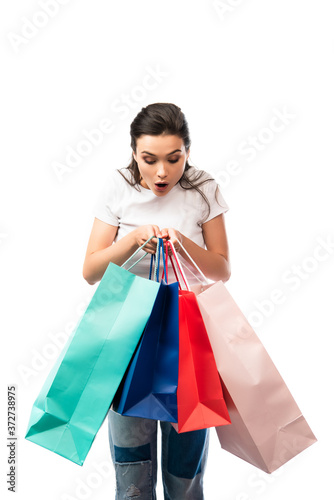 young shocked woman looking at shopping bags isolated on white