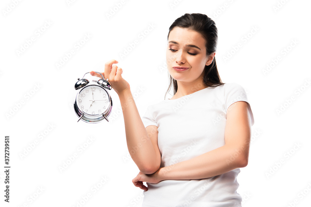 dissatisfied woman in white t-shirt looking at retro alarm clock isolated on white dissatisfied woman in white t-shirt looking at retro alarm clock isolated on white