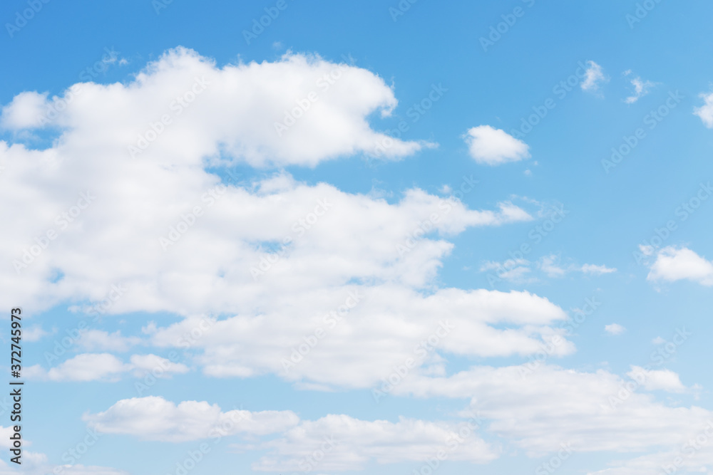White cumulus clouds against the background against blue on a blue background. White cumulus clouds against the background against blue on a blue background.