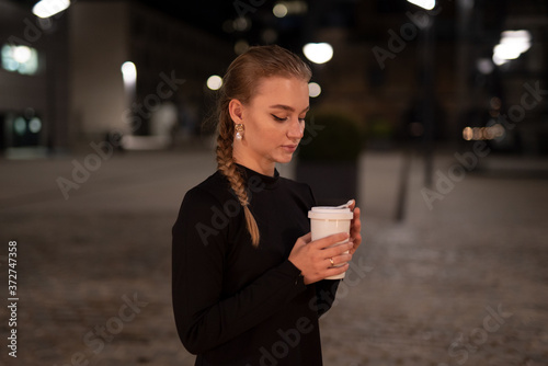 Junge Frau mit einem Kaffee  in der Hand.
Junge Frau mit einem Kaffebecher in der Hand.
Junge Frau steht in der Stadt mit einem Kaffebecher. photo