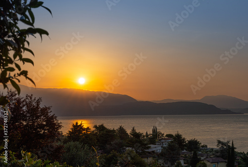 Sunrise in Manerba del Garda with the silhouettes of the mountains in the background on Lake Garda, Italy