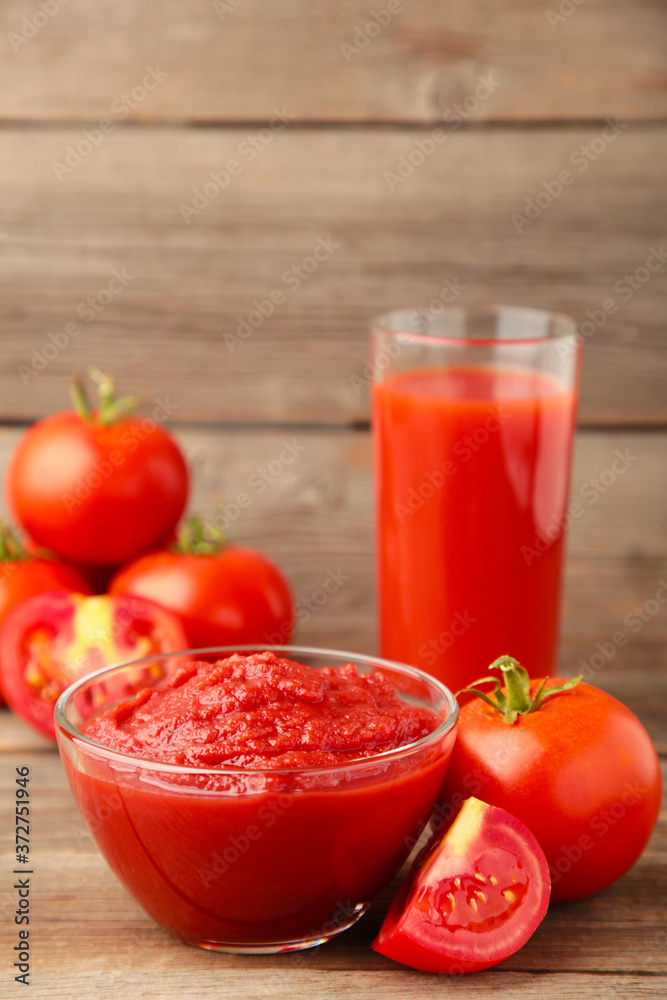Fresh tomatoes with paste and juice on grey background Fresh tomatoes with paste and juice on grey background