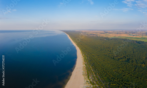 Aerial view transparent turquoise sea in Baltic Sea.Summer seascapel, beach, beautiful waves, blue water at sunset. Top view from drone