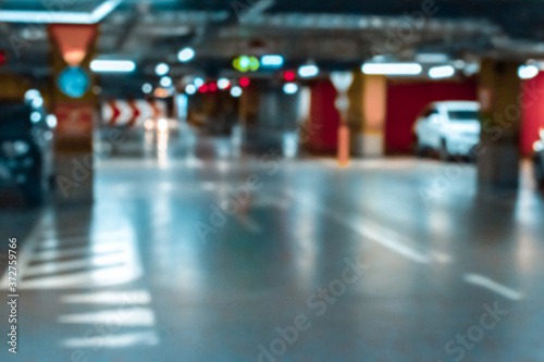 Garage car blurred. Car lot parking space in underground city garage. Empty road asphalt background in soft focus. Concrete skeleton for parking car.