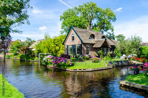 Photography Giethoorn, Netherlands: Landscape view of famous Giethoorn village with canals and rustic thatched roof houses