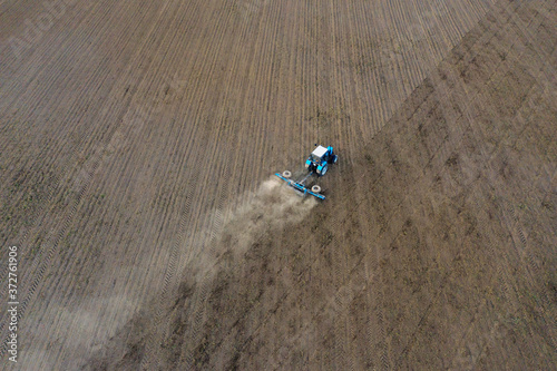 Fototapeta Naklejka Na Ścianę i Meble -  The tractor prepares the field. Drone photo