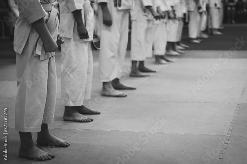 Kids training on karate-do. Black and white. Photo without faces.Simulating the grain of film photography.