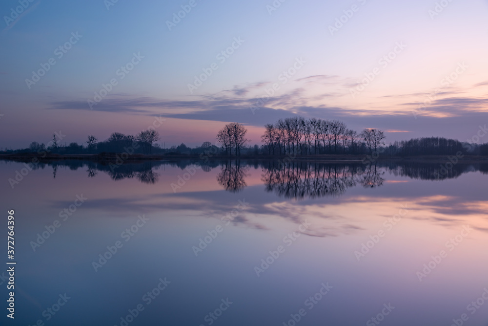 The reflection of evening clouds in calm water