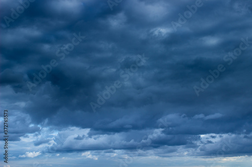 Cloudy dark blue sky. Cloudy sky with dark blue heavy clouds. Dark blue dramatic sky background.