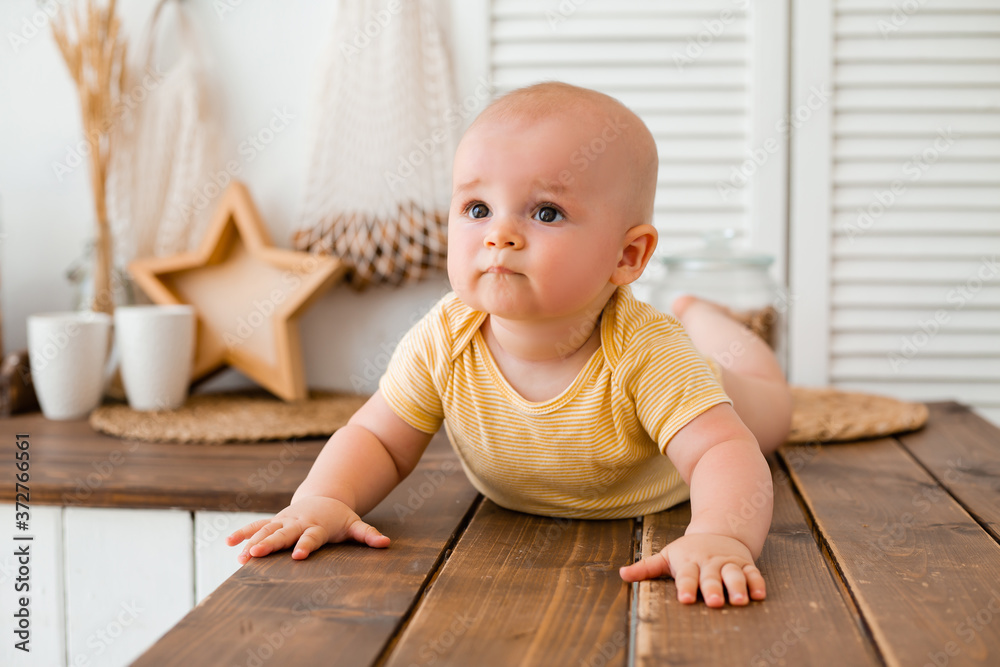 Cute toddler in the wooden kitchen of the house Cute toddler in the wooden kitchen of the house