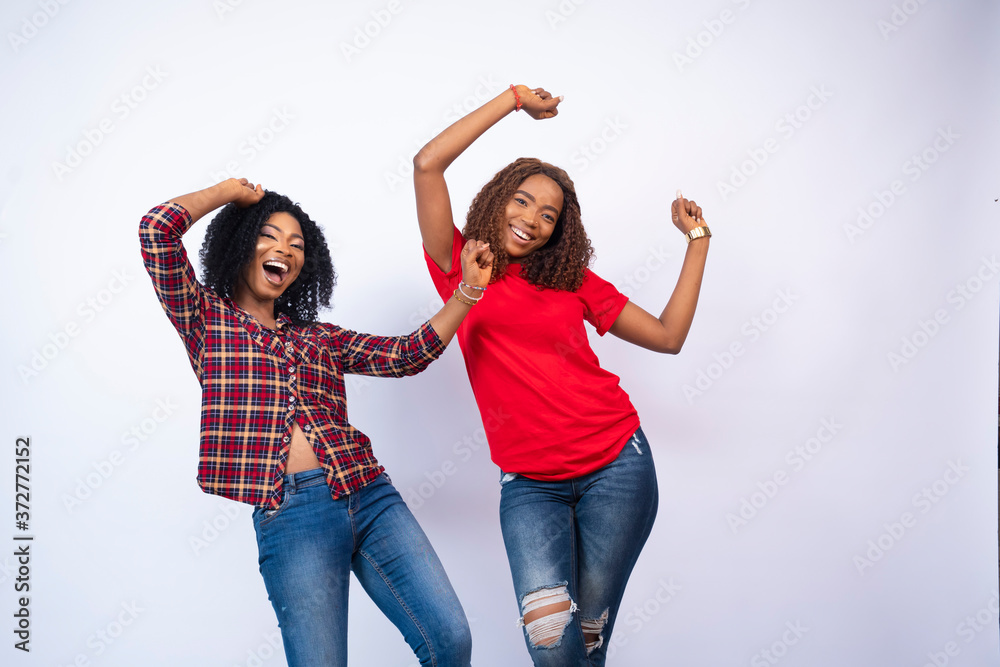 two beautiful young black women feeling excited and celebrating two beautiful young black women feeling excited and celebrating