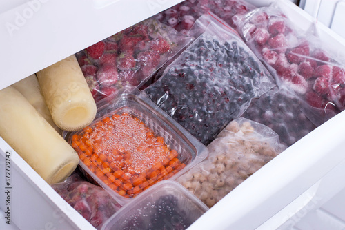 Assortment of frozen berries in plastic bags in the freezer. Frozen food in the freezer