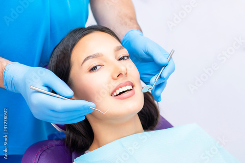 Young Female patient with pretty smile examining dental inspection at dentist clinic. Healthy teeth and medicine, stomatology concept