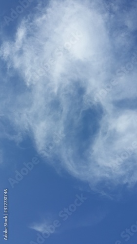 Blue sky with clouds. Wind-blowing clouds in the bright and clear sky. Transparent clouds in the light blue sky. Cirrostratus clouds dancing in the blue sky. Cirrostratus clouds and light blue skies.