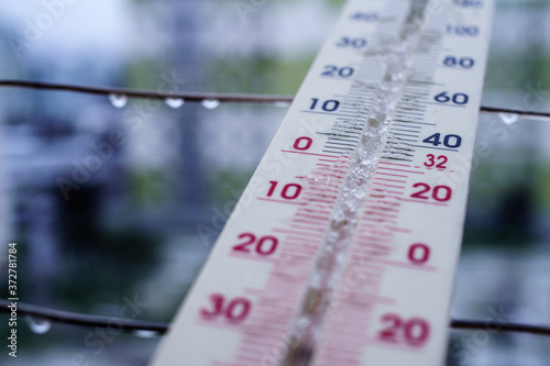 Melted snow and rain on the thermometer and cold weather in the city