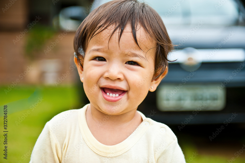 .Little girl having fun with foam while her father is washing the car in the background. Summer time fun. Smiling child. Selective focus. .Little girl having fun with foam while her father is washing the car in the background. Summer time fun. Smiling child. Selective focus.