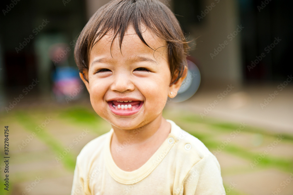 .Girl smiling and having fun with the water splashing from the hose. Summer joke. Happy child. Selective focus .Girl smiling and having fun with the water splashing from the hose. Summer joke. Happy child. Selective focus