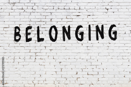 Fototapeta Inscription belonging painted on white brick wall