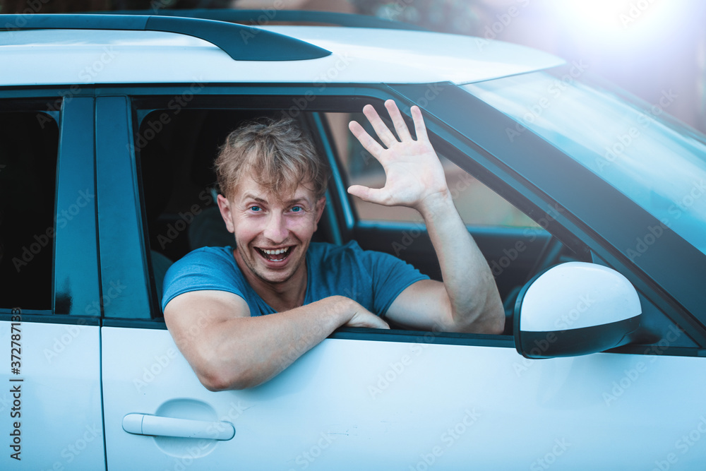 Naklejka premium Attractive elegant happy man in good car. Fun. Happy day. Smile. Travel concept. Vacation. Car. 