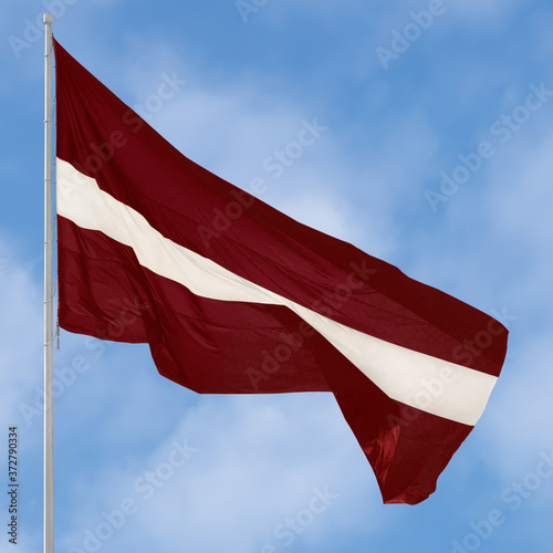 Republic of Latvia state flag, Latvian national carmine red vivid crimson and white bicolour ensign official European Union NATO member colours, large detailed vertical closeup tall flagstaff flagpost photo
