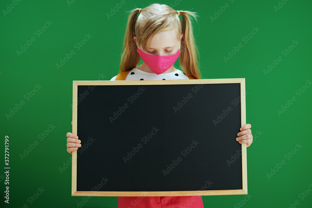 modern school girl showing blank board isolated on green modern school girl showing blank board isolated on green