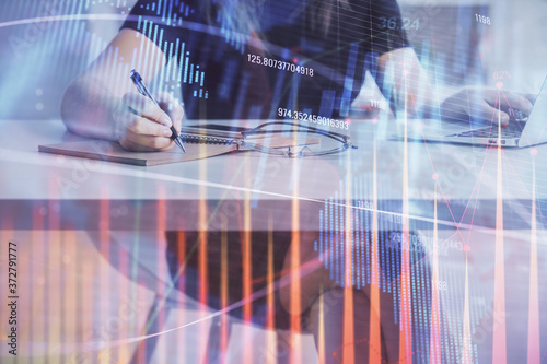 Double exposure of businesswoman hands typing on computer and forex chart hologram drawing. Financial analysis concept.