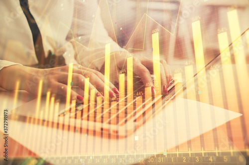 Multi exposure of woman hands typing on computer and financial graph hologram drawing. Stock market analysis concept.