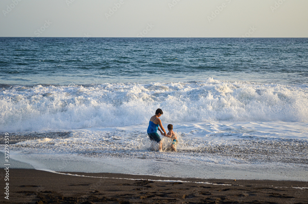 Mother and son playing in the beach.