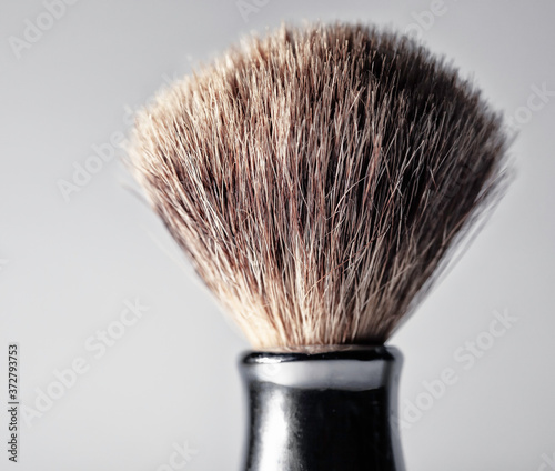 Closeup of a men's shaving brush against a neutral (white) background.