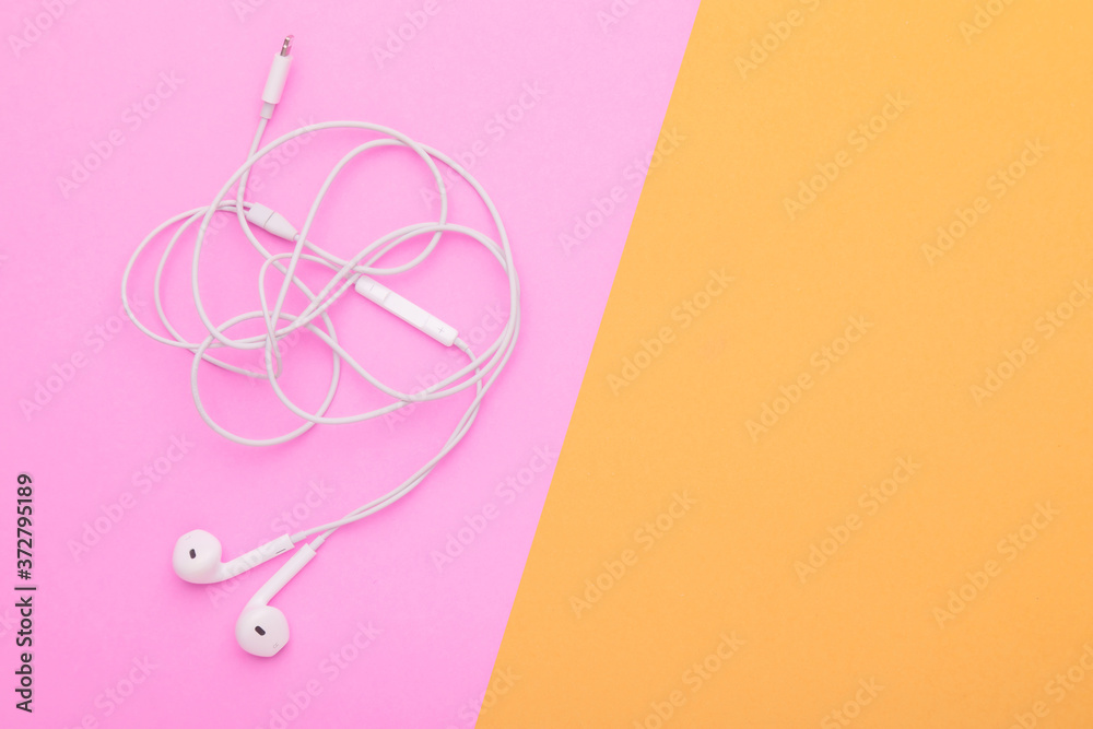 White tangle earphone on pink background. Copy space for text or design