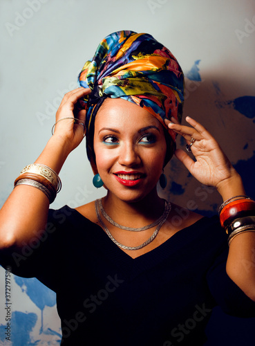 beauty bright african woman with creative make up, shawl on head like cubian closeup smiling photo