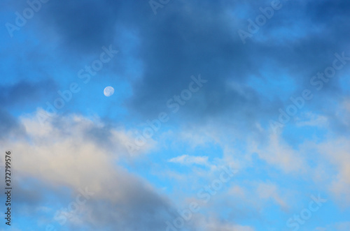 Moon in the sky covered with clouds in the early morning before sunrise