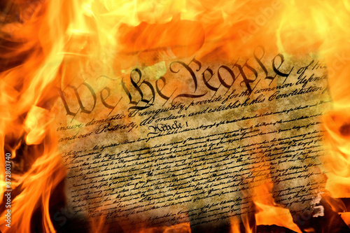 close up of United States constitution document burning in flames photo