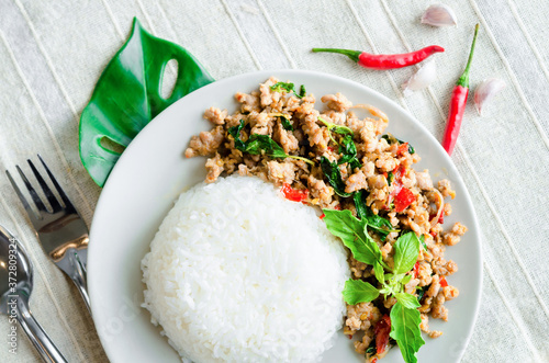 Rice topped with stir-fried pork and basil. photo