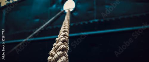 Rope that tied the ship close-up on the background of the ship's side.