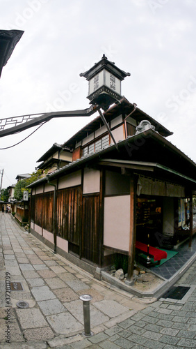  street photography of Kyoto showing old historical wooden houses, shops and rickshaw operators