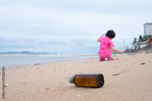 Children pick up trash on the beach, dirty sea 