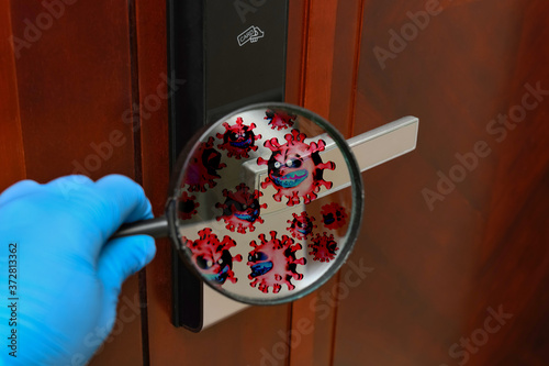 looking at the handle of a door lock via a magnifier and seeing lots of coronavirus photo