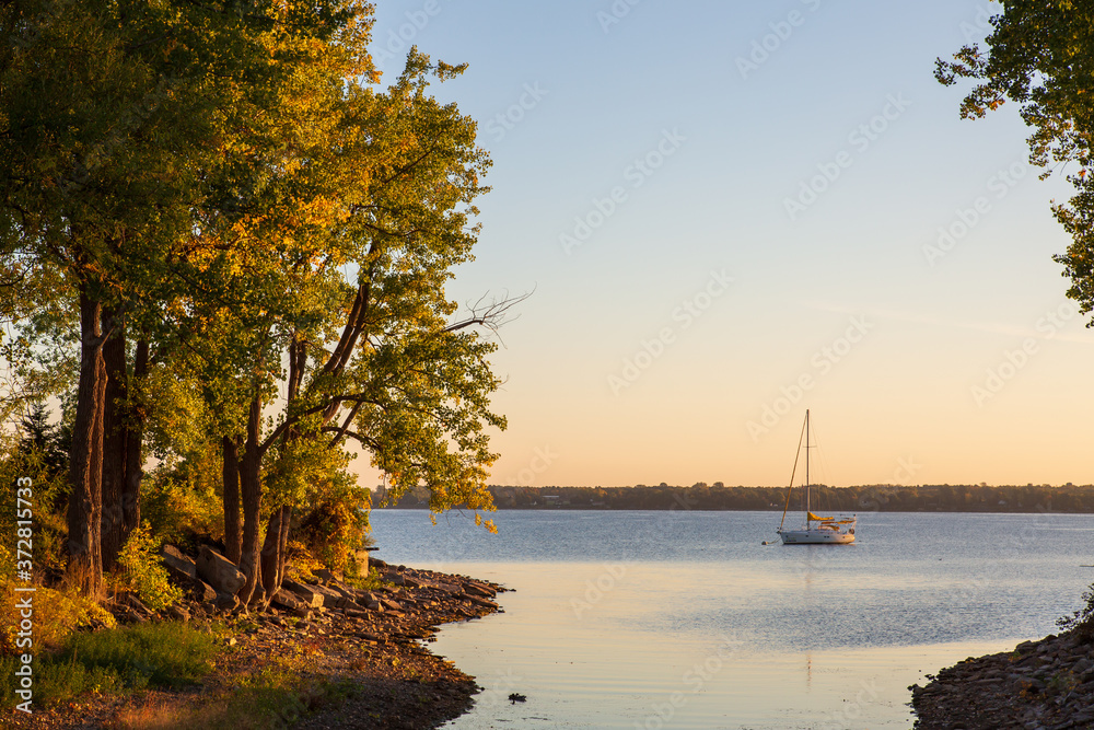 Sailboat at anchor in a beautiful bay just before sunrise in the fall