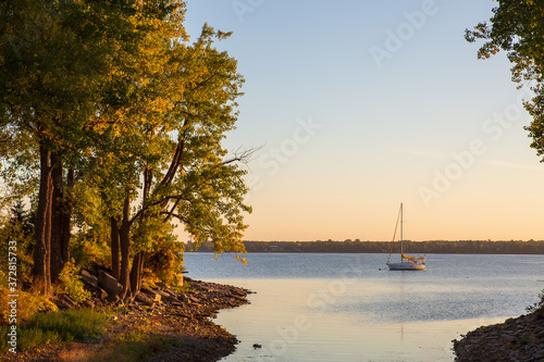 Sailboat at anchor in a beautiful bay just before sunrise in the fall