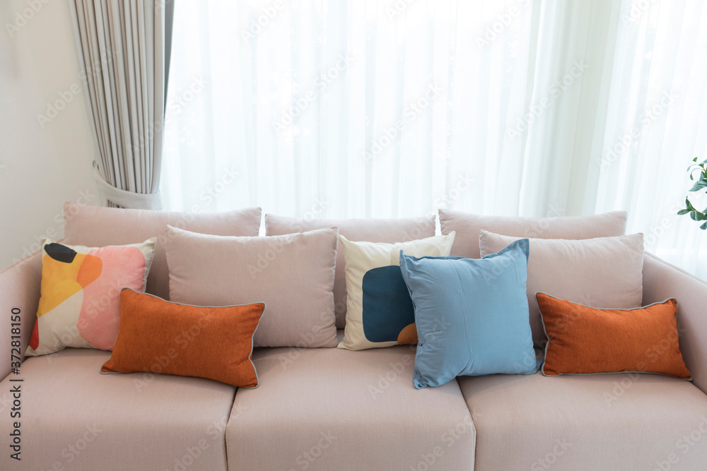 Cozy white sofa with colorful suede pillows in modern living room. Cozy white sofa with colorful suede pillows in modern living room.