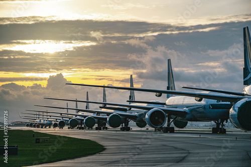 Aircraft are closely line up for long term parking at taxiway of airport due to COVID-19 