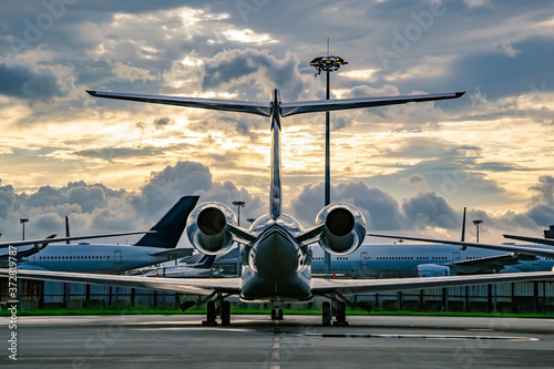 Private business jet parking at parking stand under sunset